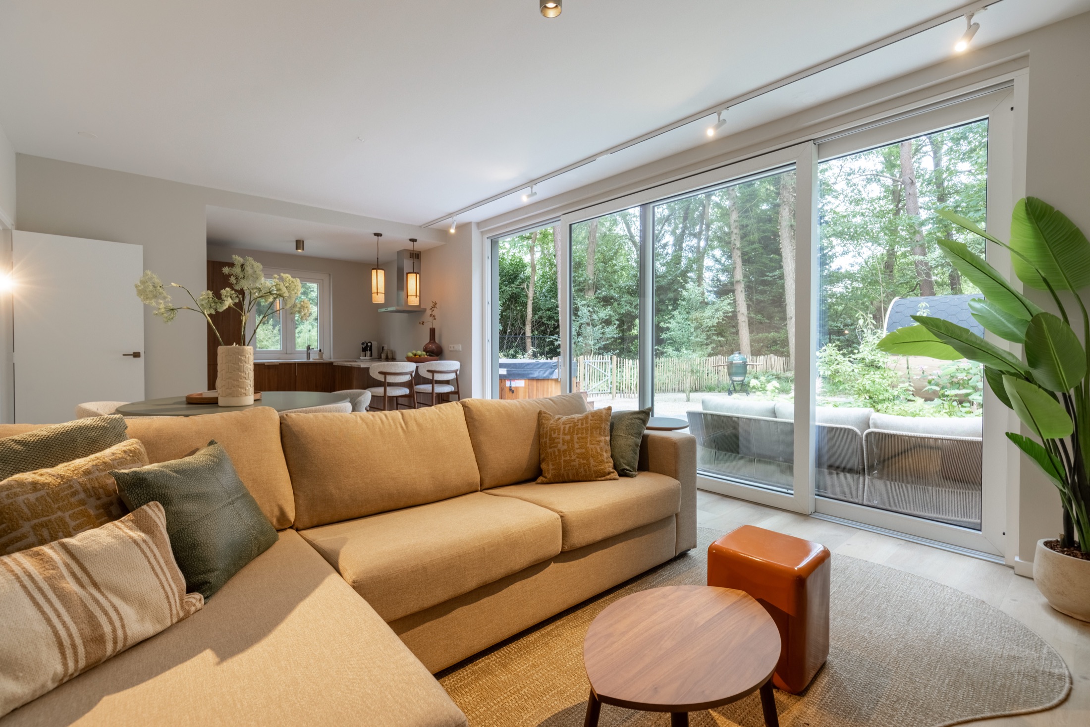 Woonkamer met grote ramen op het bos