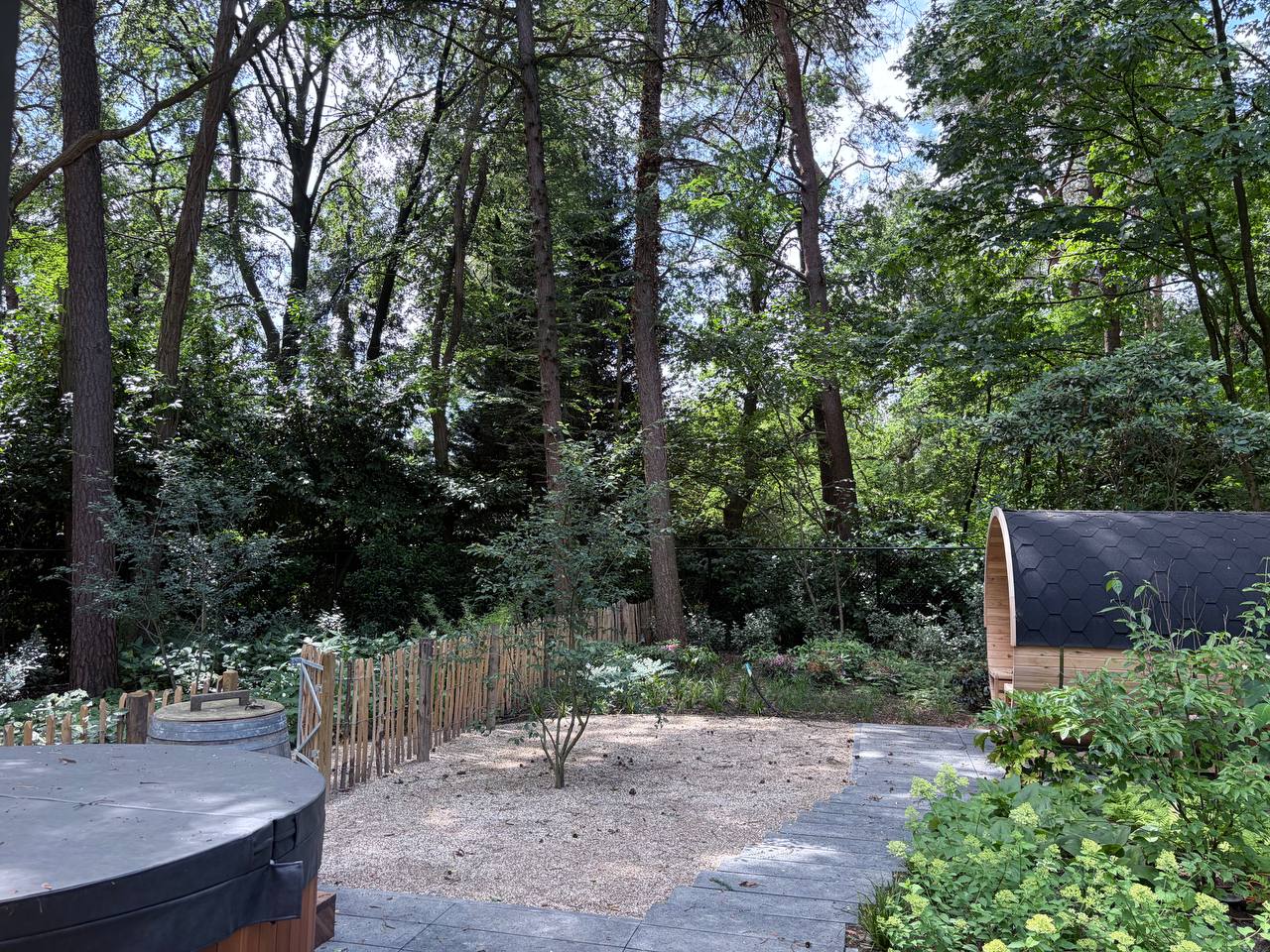 Die Fasssauna der Wellness-Cottage zwischen den Bäumen